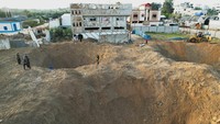 Dahsyatnya serangan roket Israel bisa dilihat dari lubang yang tercipta di tanah yang terhantam roket-roket Israel. REUTERS/Mohammed Salem.
