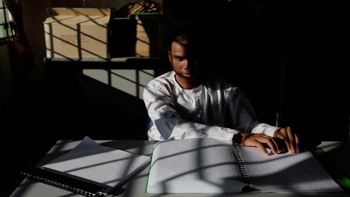 Melihat Semangat Siswa Tunanetra Menghafal Al-Qur'an Visually impaired student Aliff Haikal, 18, touches a Braille Koran as he repeatedly reads the Islamic scripture as a process of memorising it at a Koran learning institution during the holy month of Ramadan in Kuala Kubu Bharu, Malaysia April 10, 2023. REUTERS/Hasnoor Hussain