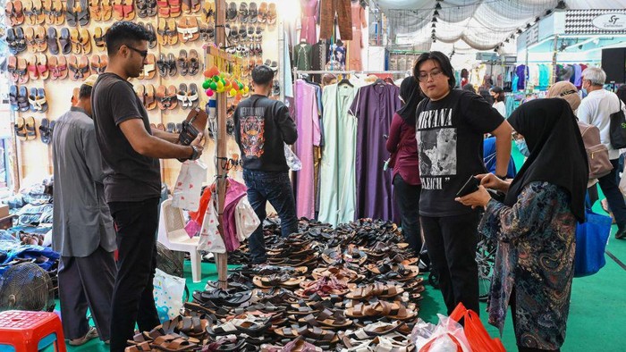 A vendor displays Malay traditional songkok caps at a temporary market set up during the Muslim holy month of Ramadan in Geylang Serai district in Singapore on April 10, 2023. (Photo by Roslan RAHMAN / AFP) (Photo by ROSLAN RAHMAN/AFP via Getty Images)