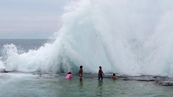 Pengunjung mengamati ombak ketika berkunjung di Pantai Batu Pecah sauri di antara Kampung Sor dan Mara, Distrik Yawosi, Biak Numfor, Papua, Minggu (9/4/2023). Pantai yang berbatasan dengan Samudera Pasifik dan menawarkan hamparan karang tersebut menjadi pilihan warga setempat untuk mengisi liburan Paskah. 
ANTARA FOTO/Sakti Karuru/nz