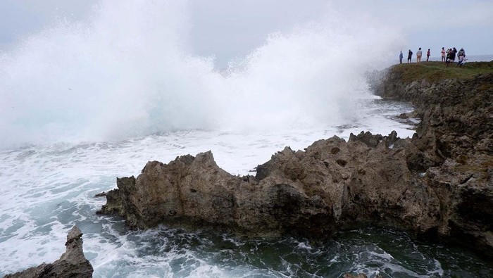 Pengunjung mengamati ombak ketika berkunjung di Pantai Batu Pecah sauri di antara Kampung Sor dan Mara, Distrik Yawosi, Biak Numfor, Papua, Minggu (9/4/2023). Pantai yang berbatasan dengan Samudera Pasifik dan menawarkan hamparan karang tersebut menjadi pilihan warga setempat untuk mengisi liburan Paskah. 
ANTARA FOTO/Sakti Karuru/nz