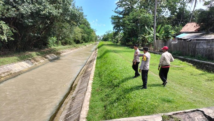 Polisi menunjukkan saluran irigasi lokasi tewasnya dua bocah di Ciwuni, Cilacap, Minggu (9/4/2023).