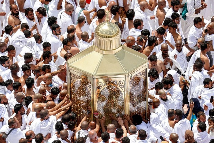 Muslim worshippers reach for a blessing as they touch the Maqam Ibrahim (Station of Abraham) at the Grand Mosque in the holy city of Mecca during the second Friday prayers in the holy month of Ramadan on March 31, 2023. (Photo by Abdel Ghani BASHIR / AFP) (Photo by ABDEL GHANI BASHIR/AFP via Getty Images)
