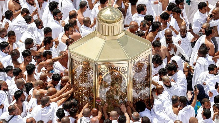 Muslim worshippers reach for a blessing as they touch the Maqam Ibrahim (Station of Abraham) at the Grand Mosque in the holy city of Mecca during the second Friday prayers in the holy month of Ramadan on March 31, 2023. (Photo by Abdel Ghani BASHIR / AFP) (Photo by ABDEL GHANI BASHIR/AFP via Getty Images)