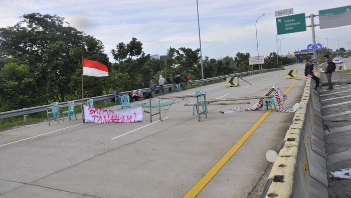 Potret Warga Lesehan Blokir Tol Jatikarya Sejumlah warga ahli waris saat melakukan aksi penutupan jalan Tol Jatikarya di Bekasi, Jawa Barat, Senin (10/4/2023). Aksi penutupan jalan tersebut menuntut pembayaran konsinyasi dari BPN (Badan Pertanahan Nasional) atas penggunaan tanah seluas 4,2 hektare untuk Tol Cimanggis-Cibitung di Jatikarya. ANTARA FOTO/ Fakhri Hermansyah/hp.