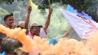 Pendemo tampak menyalakan flare.