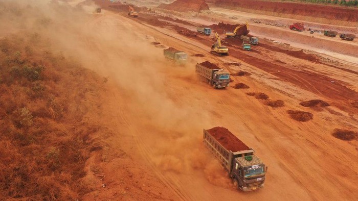 'Hujan Debu' Proyek Bandara Raksasa Vietnam Landa Permukiman dan Sekolah This aerial photograph taken on April 5, 2023 shows dust being thrown up by trucks carrying soil at the construction site of Long Thanh airport in Dong Nai province. - Red dust from the construction of a huge airport in Vietnam has rained down on thousands of people nearby for months, residents told AFP, coating trees, homes and schoolyards in a thick layer of dirt. (Photo by Nhac NGUYEN / AFP) (Photo by NHAC NGUYEN/AFP via Getty Images)