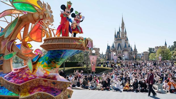 A performer waves as he takes part in a new daytime parade to mark the 40th anniversary of Tokyo Disneyland in Urayasu, in suburban Tokyo on April 10, 2023. (Photo by Richard A. Brooks / AFP) (Photo by RICHARD A. BROOKS/AFP via Getty Images)