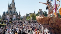 Seorang pemain berpakaian seperti karakter dari film Disney Pocahontas melihat ke arah penonton selama parade di Tokyo Disneyland, Urayasu, Tokyo, Jepang, Senin (10/4/2023).  