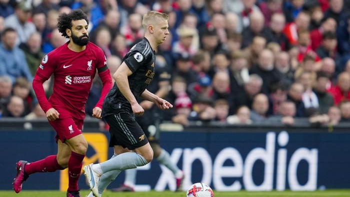 Arsenals Oleksandr Zinchenko, front, duels for the ball with Liverpools Mohamed Salah during the English Premier League soccer match between Liverpool and Arsenal at Anfield in Liverpool, England, Sunday, April 9, 2023. (AP Photo/Jon Super)