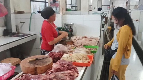 Pedagang ayam di Pasar Umum Negara saat melayani pembeli, Selasa (11/4/2023). Menjelang Lebaran harga ayam di Jembrana naik menjadi Rp 35 ribu per kilogram.