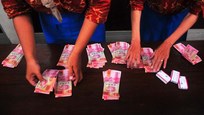 Pekerja menghitung uang tunjangan hari raya (THR) yang diterimanya saat pembagian di pabrik rokok PT Djarum, Kudus, Jawa Tengah, Selasa (11/4/2023). Perusahaan tersebut membagikan uang THR kepada 49.237 pekerja harian dan borongan yang tersebar di tujuh kota dengan total Rp117.235.986.800 guna membantu mereka dalam memenuhi kebutuhan keluarga selama bulan Ramadhan dan Idul Fitri. ANTARA FOTO/Yusuf Nugroho/nym.