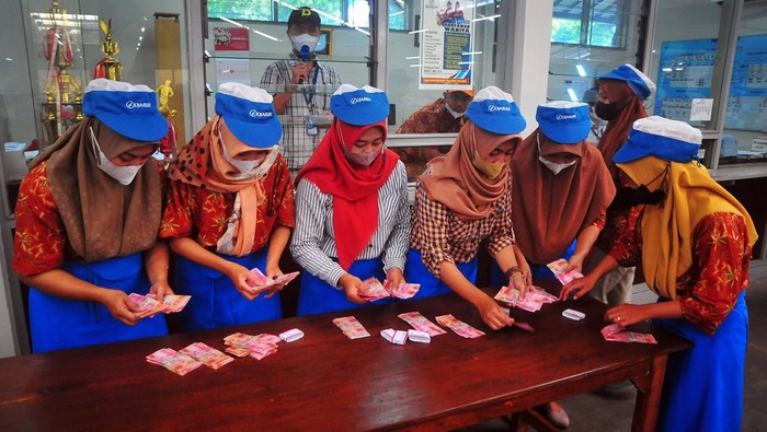 PEMBAGIAN UANG TUNJANGAN HARI RAYA Pekerja menghitung uang tunjangan hari raya (THR) yang diterimanya saat pembagian di pabrik rokok PT Djarum, Kudus, Jawa Tengah, Selasa (11/4/2023). Perusahaan tersebut membagikan uang THR kepada 49.237 pekerja harian dan borongan yang tersebar di tujuh kota dengan total Rp117.235.986.800 guna membantu mereka dalam memenuhi kebutuhan keluarga selama bulan Ramadhan dan Idul Fitri. ANTARA FOTO/Yusuf Nugroho/nym.