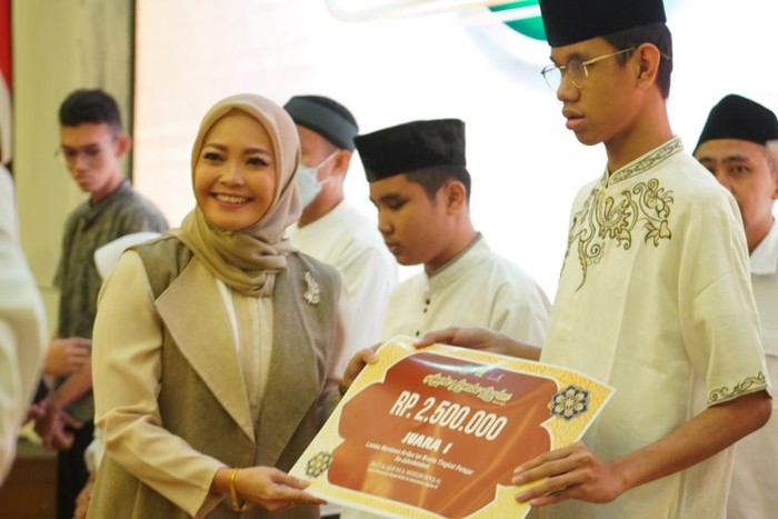 Penyerahan hadiah secara simbolis oleh Hj. Eny Yaqut Cholil Qoumas kepada Daniel Satria Ramadhan, pemenang lomba baca Al-Qur’an Braille.