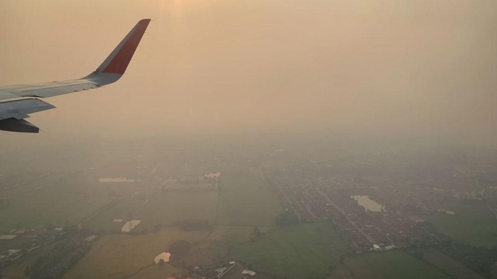 An Air Asia plane descends towards Chiang Mai International Airport amid high levels of air pollution in Chiang Mai on April 10, 2023. (Photo by Lillian SUWANRUMPHA / AFP) (Photo by LILLIAN SUWANRUMPHA/AFP via Getty Images)