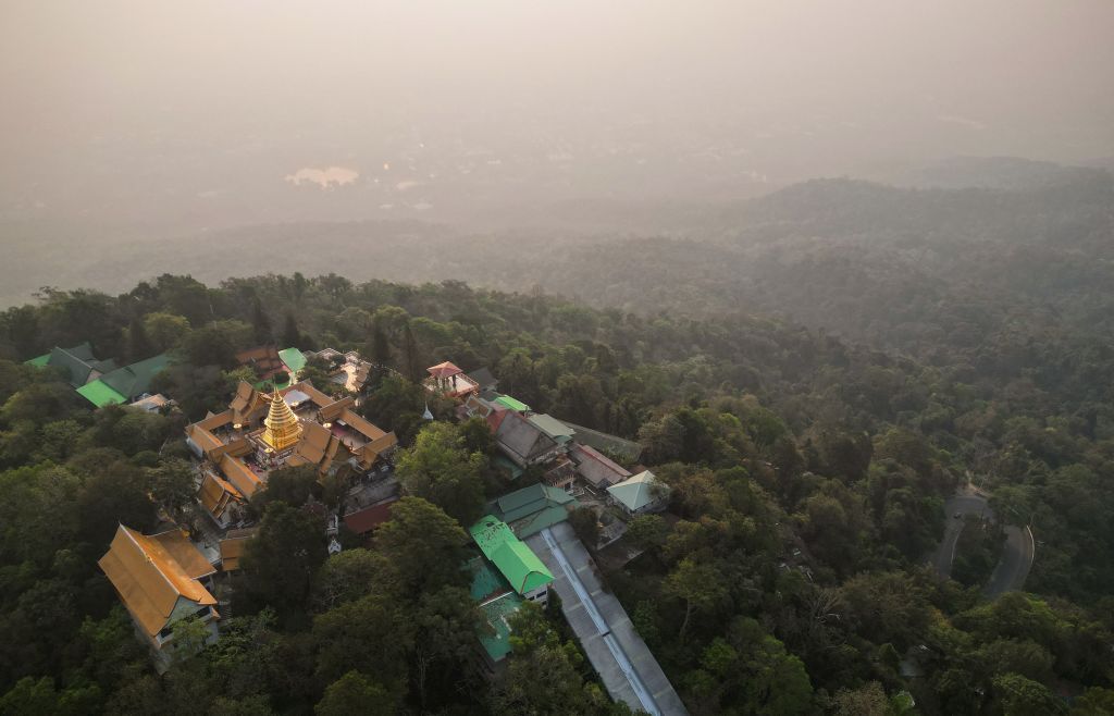 This aerial photo taken on April 11, 2023 shows Doi Suthep Buddhist temple in front of heavy pollution engulfing the city of Chiang Mai. - Northern Thailand has been choking on heavy air pollution since the start of the year, caused in part by seasonal agricultural burning. (Photo by Lillian SUWANRUMPHA / AFP) (Photo by LILLIAN SUWANRUMPHA/AFP via Getty Images)