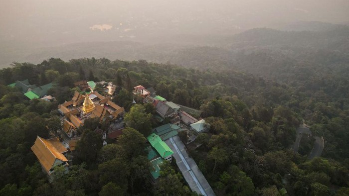 This aerial photo taken on April 11, 2023 shows Doi Suthep Buddhist temple in front of heavy pollution engulfing the city of Chiang Mai. - Northern Thailand has been choking on heavy air pollution since the start of the year, caused in part by seasonal agricultural burning. (Photo by Lillian SUWANRUMPHA / AFP) (Photo by LILLIAN SUWANRUMPHA/AFP via Getty Images)