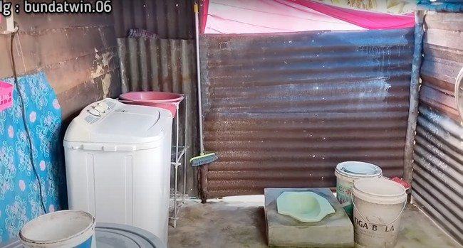 Untuk kamar mandinya sendiri masih sangat sederhana dengan hanya dilapisi seng. Terdapat closet jongkok, ember, dan mesin cuci di dalam kamar mandinya tersebut. Hingga saat ini video rumah yang satu ini telah ditayangkan lebih dari 18 ribu kali. Foto: YouTube/Bunda Twin