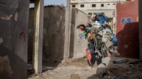 Ia mengenakan kostum dari sampah plastik yang menjuntai dari lengan dan kakinya.