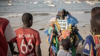 Di dada Modou, menyembul dari plastik, ada tanda dalam bahasa Prancis yang mengatakan, “Tidak untuk kantong plastik.”