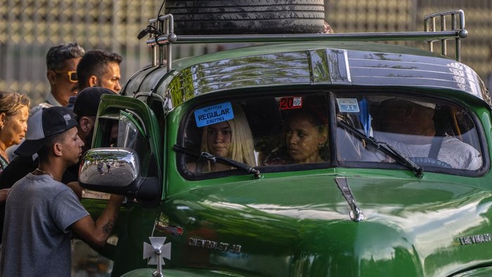 Serba Sulit Warga Kuba, Kini Berjibaku dengan Krisis Transportasi Umum People push to get into a bus completely full of customers in Havana, Cuba, Thursday, April 6, 2023. As Cuban citizens deal with the countryΒ΄s many problems like electricity blackouts, empty stores and long lines for almost any service, they also have to manage with the lack of public transportation as there is a shortage of working buses and few privately owned vehicles. (AP Photo/Ramon Espinosa)