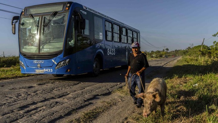 People push to get into a bus completely full of customers in Havana, Cuba, Thursday, April 6, 2023. As Cuban citizens deal with the country´s many problems like electricity blackouts, empty stores and long lines for almost any service, they also have to manage with the lack of public transportation as there is a shortage of working buses and few privately owned vehicles. (AP Photo/Ramon Espinosa)