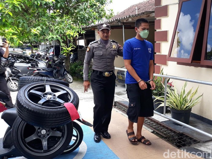 Tersangka FK beserta barang bukti empat ban mobil yang dibeli dari hasil menjual rokok curian, di Mapolsek Bantul, DIY, Selasa (11/4/2023).