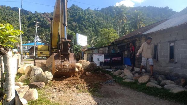 Proses pembongkaran batu yang menutupi jalan di Bungus Barat, Padang.