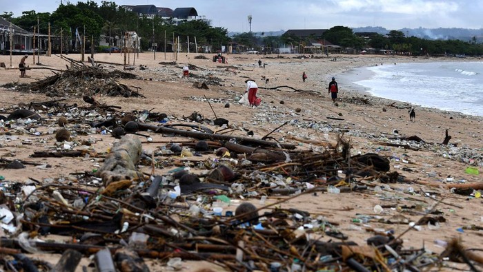 Duh, Pantai Kedonganan Bali Penuh Sampah Platik dan Kayu Trash collectors remove plastic and other debris washed ashore at Kedonganan Beach, Badung regency, on Indonesia's resort island of Bali on April 12, 2023. (Photo by SONNY TUMBELAKA / AFP) (Photo by SONNY TUMBELAKA/AFP via Getty Images)