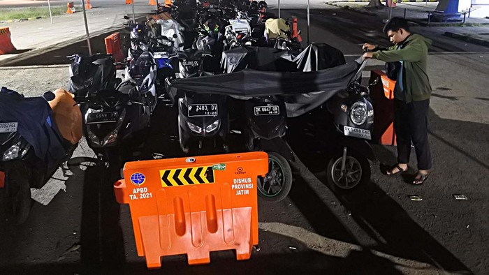 PEMUDIK MENGINAP DI RUANG TUNGGU PELABUHAN JANGKAR Seorang pemudik kapal feri melihat sepada motor yang parkir untuk antrean masuk kapal di Pelabuhan Jangkar, Situbondo, Jawa Timur, Rabu (12/4/2023) dinihari. Sejumlah pemudik yang hendak ke Pulau Raas, Sumenep, Madura sudah empat hari menginap di ruang tunggu kantor pelabuhan untuk menunggu jadwal keberangkatan kapal feri pada Kamis (13/4) besok. ANTARA FOTO/Seno/foc.