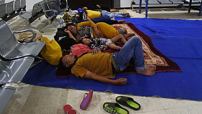 PEMUDIK MENGINAP DI RUANG TUNGGU PELABUHAN JANGKAR Seorang pemudik kapal feri melihat sepada motor yang parkir untuk antrean masuk kapal di Pelabuhan Jangkar, Situbondo, Jawa Timur, Rabu (12/4/2023) dinihari. Sejumlah pemudik yang hendak ke Pulau Raas, Sumenep, Madura sudah empat hari menginap di ruang tunggu kantor pelabuhan untuk menunggu jadwal keberangkatan kapal feri pada Kamis (13/4) besok. ANTARA FOTO/Seno/foc.