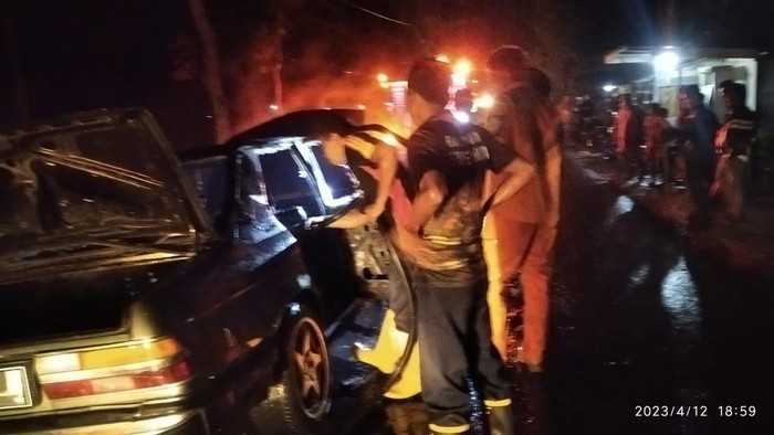 Petugas memadamkan api pada mobil sedan yang terbakar di Blora, Rabu (12/4/2023).