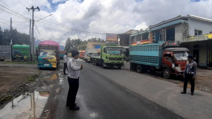 Petugas mengatur lalu lintas di tengah penerapan sistem buka tutup jalan di jalur Camba, Maros.