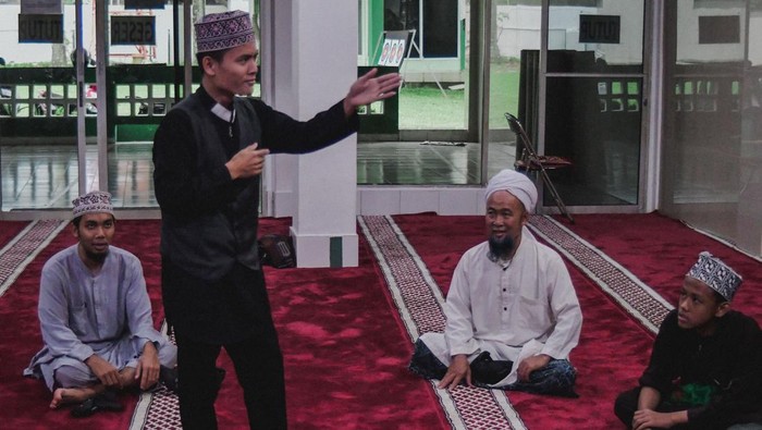 Seorang teman tuli (Mantul) Sandi (kedua kiri) didampingi penerjemah berdakwah ke rumah-rumah warga tentang Shalat wajib dengan menggunakan Bahasa Isyarat di Bekasi, Jawa Barat.