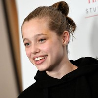 Gaya rambut diikat cepol jadi andalan Shiloh yang kini sudah remaja. Seperti gayanya saat menemani Jolie menghadiri premier Paper & Glue: A JR Project di Los Angeles pada 2021. Foto: Getty Images/Arnaldo Magnani