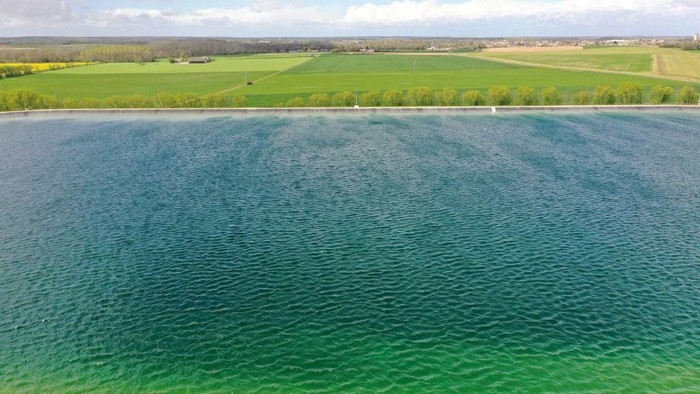 This aerial view taken on April 12, 2023 shows a water reserve for agricultural irrigation, in Mauze-sur-le-Mignon, central-western France. - The project comprises 16 reservoirs with a total capacity of six million cubic metres, planned by a cooperative of 450 farmers with state support. It aims to store water drawn from the water table in winter to irrigate crops in summer when rainfall is scarce, according to a 