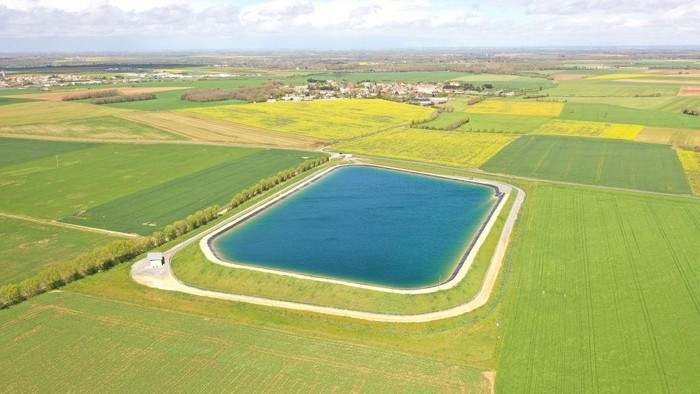 1251749457 This aerial view taken on April 12, 2023 shows a water reserve for agricultural irrigation, in Mauze-sur-le-Mignon, central-western France. - The project comprises 16 reservoirs with a total capacity of six million cubic metres, planned by a cooperative of 450 farmers with state support. It aims to store water drawn from the water table in winter to irrigate crops in summer when rainfall is scarce, according to a