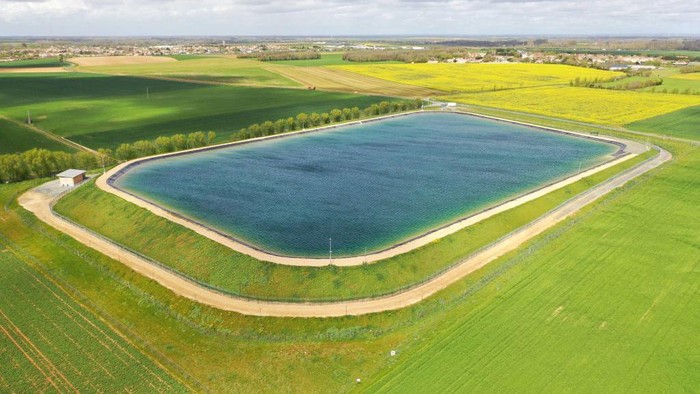 This aerial view taken on April 12, 2023 shows a water reserve for agricultural irrigation, in Mauze-sur-le-Mignon, central-western France. - The project comprises 16 reservoirs with a total capacity of six million cubic metres, planned by a cooperative of 450 farmers with state support. It aims to store water drawn from the water table in winter to irrigate crops in summer when rainfall is scarce, according to a 
