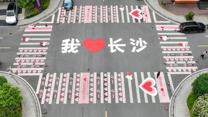 CHANGSHA, CHINA - APRIL 12: Aerial view of a zebra crossing decorated with pink heart-shaped patterns and Chinese characters reading 'I love Changsha' on April 12, 2023 in Changsha, Hunan Province of China. (Photo by Yang Huafeng/China News Service/VCG via Getty Images)