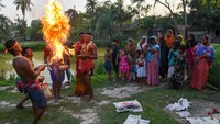 Pemuja mendandani diri mereka dengan bunga dan melempar bubuk kering yang memuntahkan api dari kuali untuk berdoa kepada Dewa Siwa selama ini.   