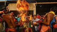 Umat hindu melakukan atraksi melemparkan api selama festival Gajon di sebuah desa 100 kilometer dari Kolkata, India, Rabu (12/4/2023).