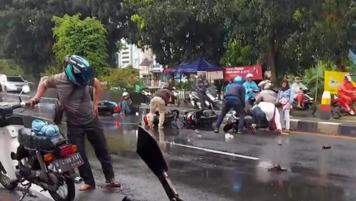 Empat pemotor berjatuhan di Jalan Raya Bogor, Cibinong, gegara jalanan licin.