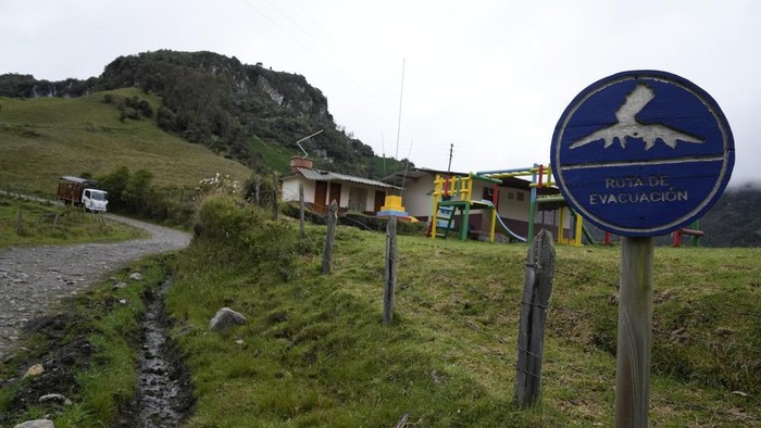 An evacuation route signal stands outside the Lepanto Technical Educational Institution that was closed due after the Nevado del Ruiz Volcano showed high levels of seismic activity in Murillo, Colombia, Tuesday, April 11, 2023. Colombian officials began to evacuate some families after the volcano showed high levels of seismic activity that could signal an eruption in the coming days or weeks. (AP Photo/Fernando Vergara)