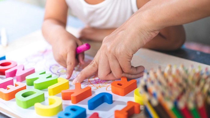 Asian little girl is learning English letters.