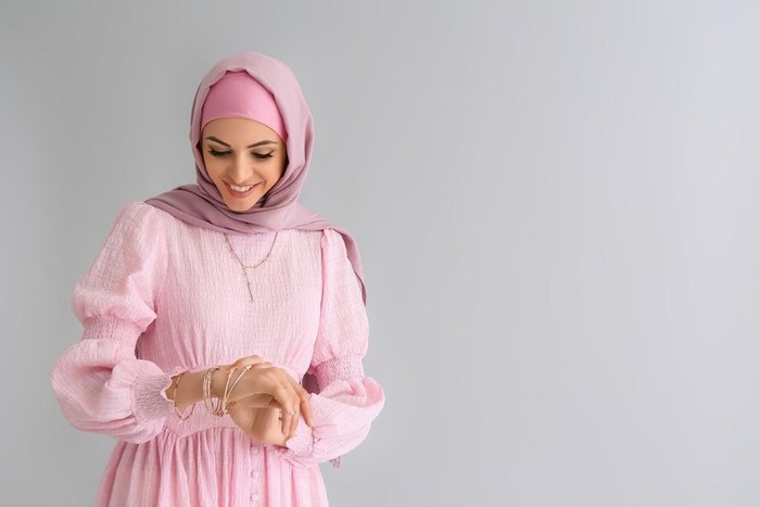 Ilustrasi wanita berhijab mengenakan gamis berwarna pink