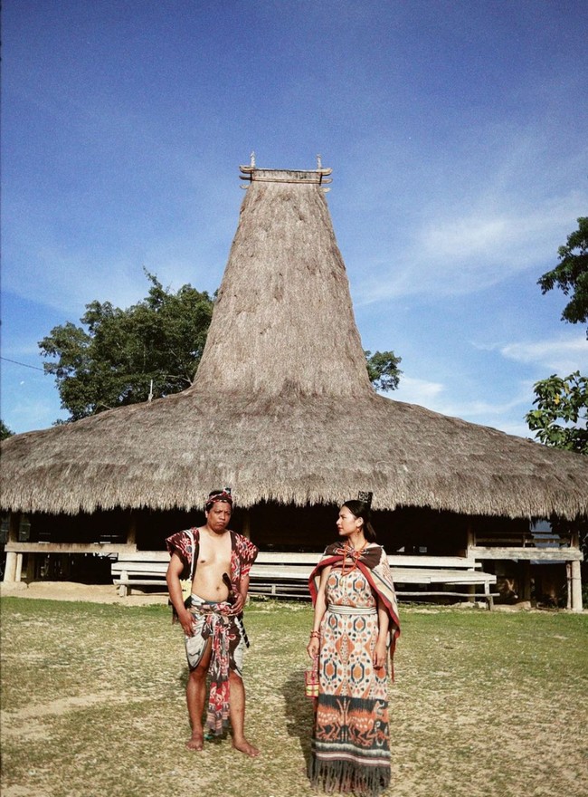 Tak hanya sekedar berjalan-jalan, Arie dan Indah juga mencoba mengenakan kain dari Sumba. Keduanya tampak berpose di Kampung Raja Prailiu, Waingapu Sumba. Foto: Instagram/@indahpermatas