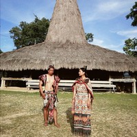 Tak hanya sekedar berjalan-jalan, Arie dan Indah juga mencoba mengenakan kain dari Sumba. Keduanya tampak berpose di Kampung Raja Prailiu, Waingapu Sumba. Foto: Instagram/@indahpermatas
