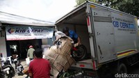 Pekerja menaikkan sepeda motor yang akan dikirim ke luar kota ke dalam mobil box di Jalan Bungur Besar Raya, Senen, Jakarta, Kamis (13/4/2023).
