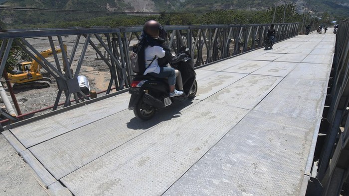 Jembatan Amblas di Jalur Mudik Kota Palu-Donggala, Kini Sudah Bisa Dilewati Pengendarar sepeda motor melintasi jembatan darurat yang dipasang pada badan jembatan yang ambles di Kelurahan Buluri di Palu, Sulawesi Tengah, Kamis (13/4/2023). Kementerian PUPR melalui Balai Pelaksanaan Jalan Nasional (BPJN) Provinsi Sulawesi Tengah menyelesaikan pembangunan satu jembatan darurat untuk menghubungkan kembali jembatan yang ambles dan sempat memutus jalur mudik penghubung Kota Palu dan Donggala hingga ke Sulawesi Barat dan Sulawesi Selatan. ANTARA FOTO/Mohamad Hamzah/tom.