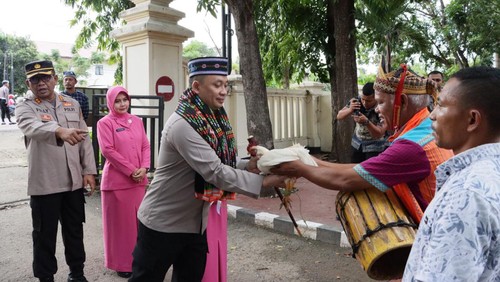 Kapolres baru Manggarai Barat AKBP Ari Satmoko menerima seekor ayam dari tetua adat saat acara penyambutan dengan ritus adat Tuak Curu dan Manuk Kapu di Mako Polres Manggarai Barat di Labuan Bajo, Kamis (13/04/2023). (Istimewa)